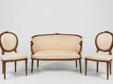 trois chaises et un canapé dans une pièce aux murs blancs