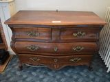 a wooden chest of drawers in a room next to a radiator