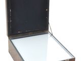 une valise contenant un miroir, posée sur une surface blanche