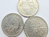 three different british coins sitting on top of a white surface