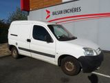 La camionnette blanche est garée devant un immeuble sur lequel est accrochée une pancarte « balcon encheres ».