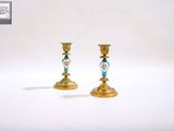 deux bougeoirs en or ornés de motifs bleus et roses