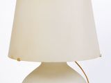 la lampe est blanche et est équipée d'un abat-jour blanc