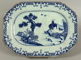 a blue and white plate with a picture of a man riding a horse