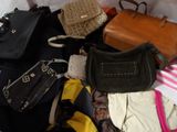 a lot of purses that are sitting on a bed