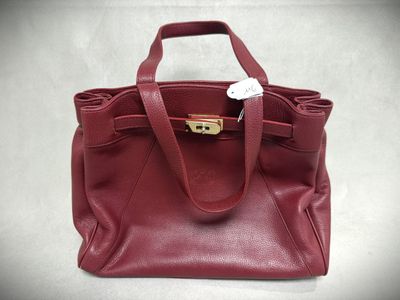a close up of a red purse on a white surface