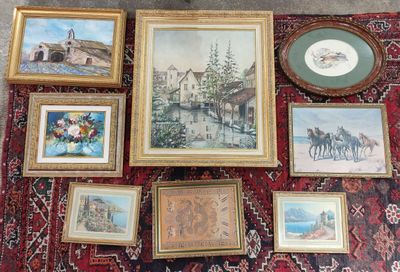 many framed pictures on a rug on the floor