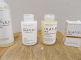 three bottles of olaplex on a table next to a box of shampoos