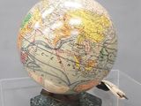 un globe terrestre posé sur un socle et sur lequel figure une carte