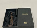 une boîte noire contenant une statuette, posée sur une table