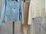 two jackets and a skirt on a rack in a room