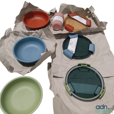 de nombreux bols et assiettes de différentes couleurs sur la table