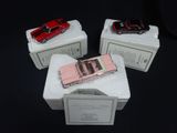 three toy cars sitting on top of boxes on a table