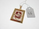an image of a gold and red pendant with a tag on it