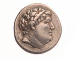 une vieille pièce de monnaie sur laquelle figure la tête d'un homme, sur un fond blanc