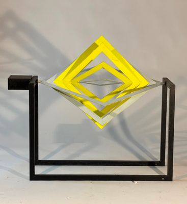 an image of a yellow and black sculpture on a white surface