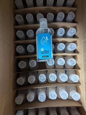 a cardboard box filled with bottles of water and a bottle of liquid