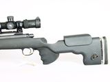 the rifle is laying on a white surface with a red dot in the foreground