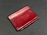 leather wallet with pen on a black surface