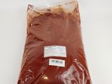 un sachet de poudre rouge posé sur une surface blanche