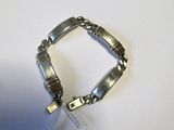 un gros plan d'un bracelet en argent auquel est attachée une chaîne