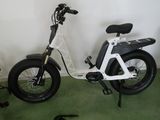 une trottinette électrique blanche avec un siège noir dans une pièce