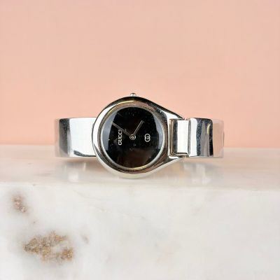 un gros plan d'une montre posée sur une surface en marbre