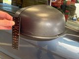 a hand holding a ruler that is next to a helmet