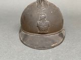 a silver bell with a rabbit on it on a table