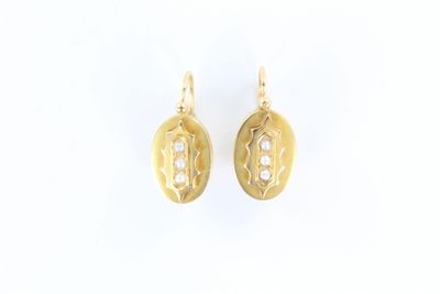 une paire de boucles d'oreilles en or ornées de perles sur fond blanc