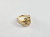 a close up of a gold signet ring on a white surface