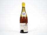 the bottle of wine is sitting on a white surface