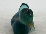 a glass duck that is sitting in the snow