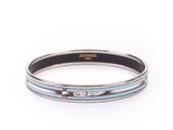 un gros plan d'un bracelet argenté et bleu sur fond blanc