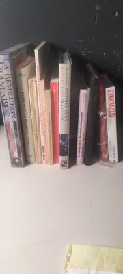 Plusieurs livres sont alignés sur une étagère à côté d'un ordinateur portable