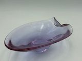 purple glass bowl sitting on top of a white surface