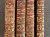 trois vieux livres posés l'un sur l'autre sur une table
