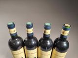four bottles of wine are lined up on a table