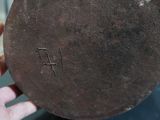 a person holding a metal object with the word j f written on it