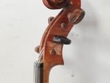 a close up of a violin on a stand against a white wall