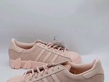 une paire de baskets Adidas roses sur fond blanc