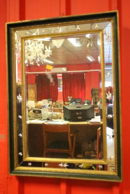 a mirror hanging on a red wall in a room