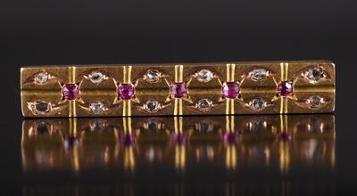 a close up of a gold plated bracelet with pink stones