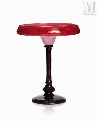une table en verre avec un plateau rouge et un piètement noir