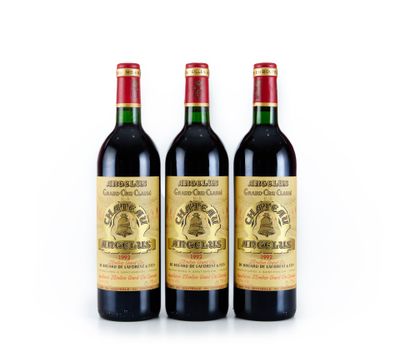 trois bouteilles de vin posées les unes à côté des autres sur une surface blanche