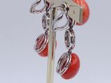 pair of red coral and silver earrings on a silver stick