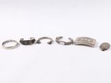 a group of five silver rings and a silver ring on a white surface