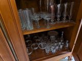 a wooden cabinet with many glasses on top of it
