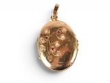 a close up of a gold locke with a flower design on it
