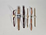 quatre types de montres sont alignés sur une surface blanche